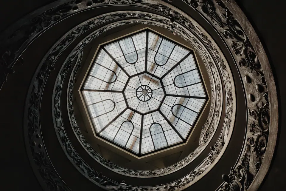 Circular skylight framed by carved stone geometry.